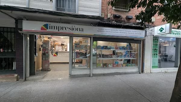 Exterior de la tienda Impresiona en Sevilla con muestras de productos impresos y área de atención al cliente Exterior de la tienda Impresiona en Sevilla con muestras de productos impresos y área de atención al cliente
