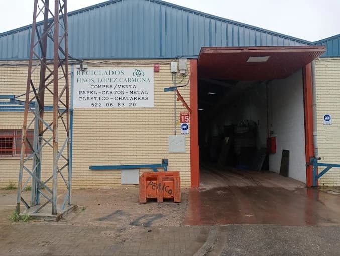 Fachada de las instalaciones de Reciclados Hermanos López Carmona en Sevilla con contenedores de reciclaje Fachada de las instalaciones de Reciclados Hermanos López Carmona en Sevilla con contenedores de reciclaje
